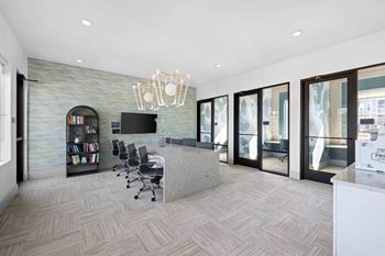 A modern office with a grey stone wall and a grey reception desk at The Quinn Luxury Apartments, Pensacola